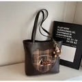 Detailansicht der braunen Ledertasche mit Dackel-Stickerei und Herz-Karomuster-Patchwork - Mit Anhänger / Braun