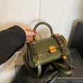 Vintage olivgrüne glänzende Lederhandtasche mit goldenen Beschlägen und Anhängern - Grün mit Anhänger