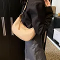 Dettaglio della borsa a mezzaluna beige in pelle a grana fine indossata dal modello - Kaki / 24.5*7.5*20