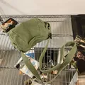 Detailopname van groene canvas schoudertas met verstelbare riem en textuur van de stof - Groen