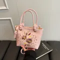Sac seau rose orné d'une broderie florale élégante avec une bandoulière réglable - Rose