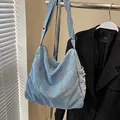 Borsa a tracolla in denim lavato azzurro con dettagli floreali bianchi sfrangiati - Blu