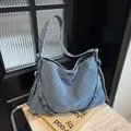 Borsa a spalla in denim azzurro con lavaggio vintage e anelli metallici decorativi - Azzurro
