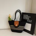 Striped woven shoulder bag in black with yellow accents and pearl button detail - Black