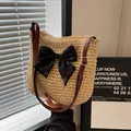 Beige handwoven straw shoulder bag with a large black bow and brown leather strap - Solid Bow Decor Beige
