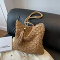 Light brown hollow woven straw tote bag with long tassel and wooden bead detail - Khaki