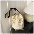 Detail van beige geweven emmerzak met zwarte lederen schouderriem en metalen gesp - Broken Wit