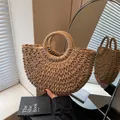 Detailansicht der gewebten Textur der beigen Strohhandtasche mit runden Griffen - Groß Khaki