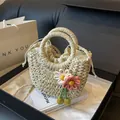 Detailed texture of handwoven straw bag featuring delicate knit flowers and drawstring liner - Cream Pink Floral