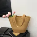 Brown lace woven beach tote bag with floral patterns holding pink tulips on a bench - Khaki