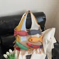 Bohemian knit tote bag with 3D colorful fish and long fringes on a leather sofa - Khaki