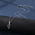 Close-up of a polished stainless steel letter F pendant on a delicate chain necklace - Letter F