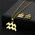 Set di collana e orecchini Aquarius dorati minimalisti su una scatola di gioielli nera - Acquario