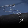 Macro shot of silver cursive letter H pendant on a polished stainless steel chain - Letter H