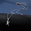Polished silver stainless steel letter K pendant on a fine chain over a dark backdrop - Letter K