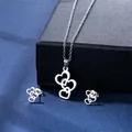 Silver heart jewelry set with necklace and stud earrings on dark textured background - Triple Heart Style (TZ-133)