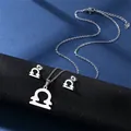 Detailed view of silver Libra zodiac necklace and stud earrings set on a display stand - Libra (Silver)