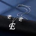Detailansicht der polierten Edelstahl-Halskette und Ohrringe mit kursivem Buchstaben E - Buchstabe E / Silber