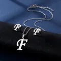 Detailsicht der silbernen Edelstahlkette und Ohrstecker mit geschwungenem Buchstaben F - Buchstabe F / Silber