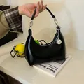 Detalle de bolso hobo de cuero negro con herrajes plateados y un colgante de esfera - Negro