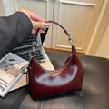 Bolso hobo media luna rojo oscuro brillante con un colgante decorativo de bola plateada - Burdeos