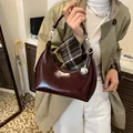 Bolso de hombro media luna en cuero charol burdeos con colgante de bola plateada - café
