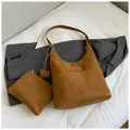 Detail eines braunen Wildleder-Shoppers mit weißen Kontrastnähten und kleiner Reißverschlusstasche - Braun
