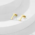 Dettaglio dell'orecchino a lobo dorato lettera I su supporto geometrico bianco - Lettera I / Oro