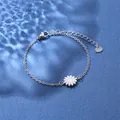 Macro shot of silver stainless steel chain bracelet featuring a white daisy pendant charm - Daisy Style (XLY29 Steel)