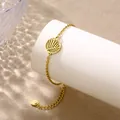 Dettaglio del bracciale dorato in acciaio con ciondolo a foglia su supporto bianco - Foglia di Palma (XLJ133)