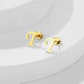 Dettaglio degli orecchini a lobo lettera T in oro lucido con chiusura a farfalla su bianco - Lettera T / Oro