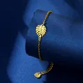 Bracciale a foglia di monstera in acciaio inossidabile dorato su espositore blu - Stile Foglia di Monstera (XLJ101)