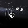 Polished stainless steel heart necklace and earrings set on a black leather display stand - Nested Heart Style (TZ-449)
