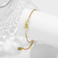 Bracciale in acciaio inossidabile dorato con motivo a fiori e foglie su colonna bianca - Maggio