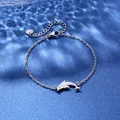 Macro view of silver dolphin pendant on a fine link chain with S925 engraved heart charm - Dolphin Style (XLY118)