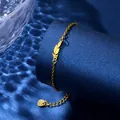 Detail of a gold feather pendant bracelet with a heart charm on a blue background - Feather Shape Style (XLJ128)