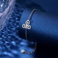 Detail of stainless steel bracelet with triskelion charm on blue textured display - Triskelion Style (XLY134)