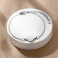 Dettaglio del bracciale a catena con ciondolo a pianeta in acciaio inox e chiusura a moschettone - Stile Pianeta Saturno (XLY175) / Argento