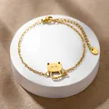 Vista macro di un bracciale gatto dorato con etichetta in acciaio inossidabile e moschettone - Gatto Cavo (XLJ181)