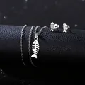 Detailed view of silver stainless steel fishbone necklace and earrings on black leather - Creative Fishbone Style (TZ-415)