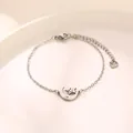 Bracciale minimalista in acciaio inossidabile con ciondolo luna e stella su un piatto bianco - Argento