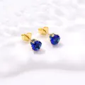 Détails macro de boucles d'oreilles couronne en zircon bleu roi et griffes dorées - Bleu foncé