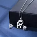 Macro view of minimalist cutout cat pendant and stud earrings set on blue texture - Hollow Cat Style (TZ-122)