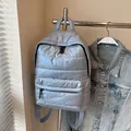 Quilted light blue puffer backpack made of shiny metallic fabric with adjustable straps - Blue