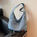 Light blue denim hobo tote bag with a front pocket and brown leather patch accent - Light Blue