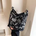 Retro shoulder bag with black and white floral embroidery and bronze metal hardware - Black