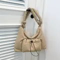 Quilted beige puffer shoulder bag with a functional drawstring pocket and knotted strap - Khaki