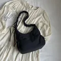 Minimalist black padded nylon cloud bag with ruched shoulder strap and drawstring detail - Black