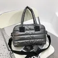 Chic silver metallic quilted puffer tote bag with black handles and a wide shoulder strap - Gray