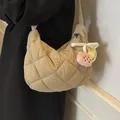 Beige quilted nylon crescent crossbody bag with cute plush fruit charms on model - With Pendant / Khaki